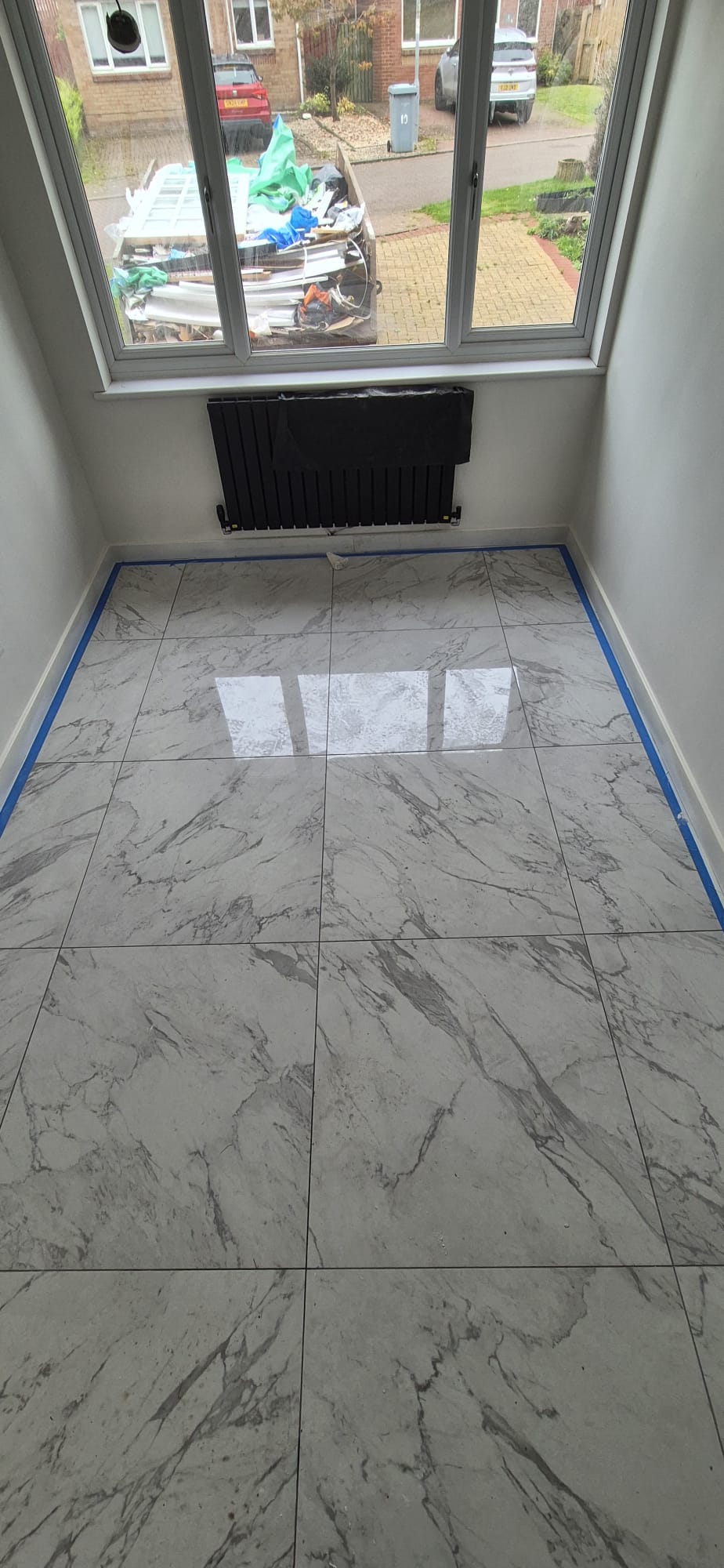 Finished floor with large-format polished marble-effect porcelain tiles